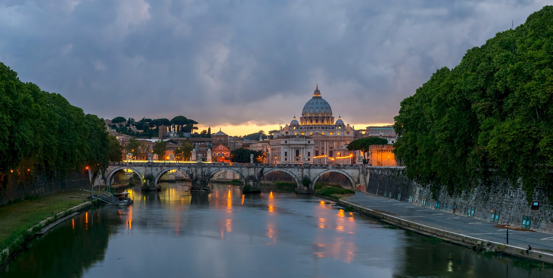 River Tiber lined with trees and the view of the St Peter's Basilica
